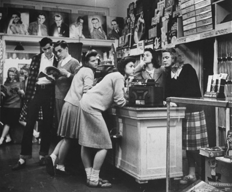 Teenagers back  listening to 45 rpms in a US record store.