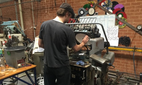 Zenith Records employee in front of a pressing machine