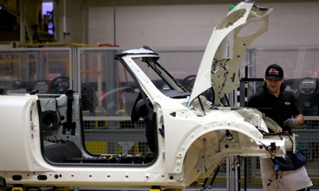 Factory workers produce Mini cars at the BMW plant at Cowley in Oxford.