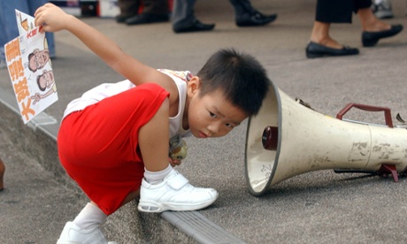 Young boy puts his ear to megaphone.