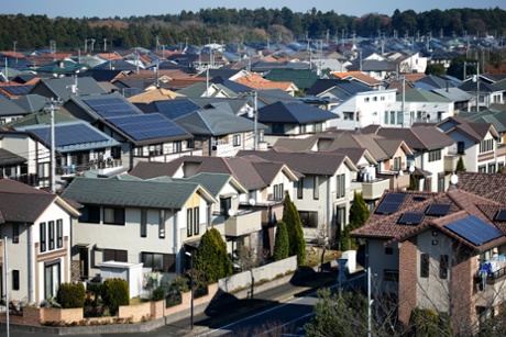 Solar panels sit on house roofs in Inzai, Chiba Prefecture, Japan, on December 9, 2014. Japans recession was deeper than initially estimated as company investment unexpectedly shrank, a blow to Prime Minister Shinzo Abe as he campaigns for re-election on his economic credentials.