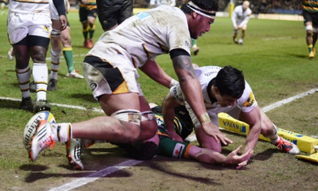 Northampton's George North is caught in the head by Nathan Hughes after scoring a try against Wasps.