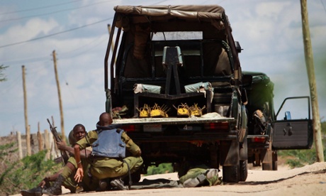 Kenyan soldiers take cover as shots are fired in front of Garissa university in Garissa town, near the border with Somalia.