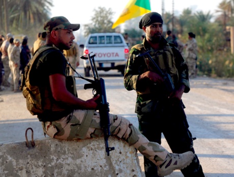 Shia fighters guard a checkpoint just south of Baghdad.