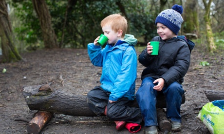 Students have a hot chocolate break in the forest.