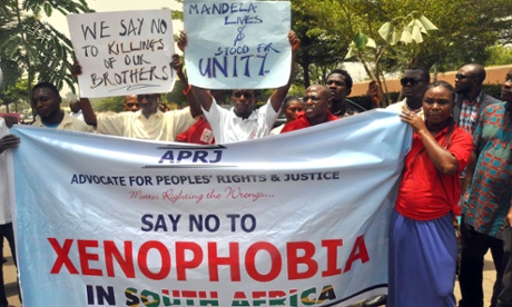 Demonstrators hold banners during a rally called by the NGO Advocate for Peoples' Rights and Justice in front of the office of the South African television DSTV, on April 20, 2015 in Abuja, Nigeria to protest against anti-immigrant violence in South Africa