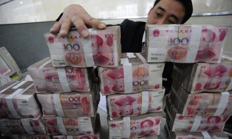 An employee counts Renminbi banknotes at a Bank of China branch 