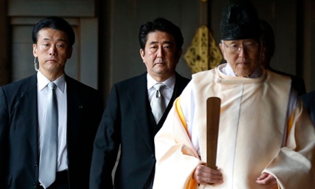 Japan's Prime Minister Shinzo Abe (C) is led by a Shinto priest as he visits Yasukuni shrine in Tokyo in this December 26, 2013 file photo. A Japanese cabinet member visited a shrine seen by critics as a symbol of Tokyo's wartime aggression on Wednesday, pouring salt on a fresh wound after Prime Minister Shinzo Abe's pilgrimage there last week drew sharp criticism from China and South Korea. REUTERS/Toru Hanai (JAPAN - Tags: POLITICS CONFLICT):rel:d:bm:GF2E9CQ08UC01