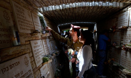 An Israeli soldier lays flowers on the memorial wall at Jerusalem’s Mount Herzl military cemetery.