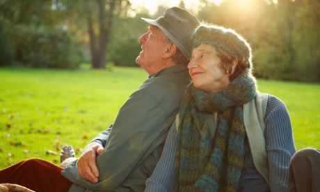Older couple sitting on the grass in a park