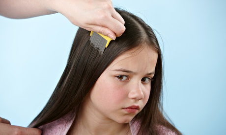 Parent combing daughter's hair with headlice comb