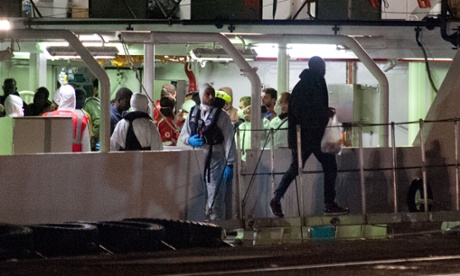 Migrants who survived the Mediterranean shipwreck arrive in Catania, Sicily, aboard an Italian coastguard vessel.