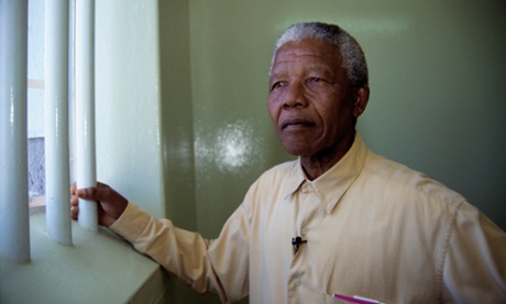 Nelson Mandela stands at the window of the cell in Robben Island prison