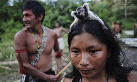 A Munduruku Indian woman warrior carries a monkey on her head in western Para state
