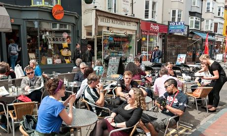 People eating and drinking at tables outside in Brighton, England