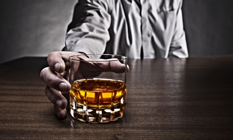 A man grabbing a glass of whisky