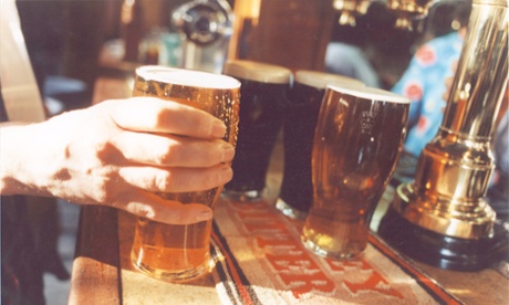 A pint of beer, settling on a pub bar.