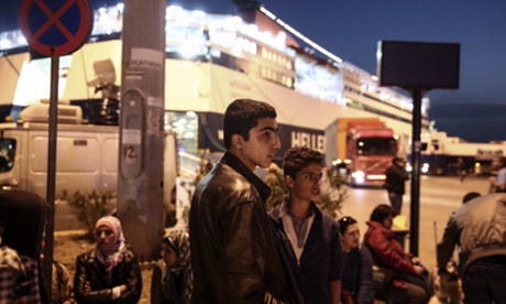 Migrants stand on a promenade after their arrival from the island of Lesvos to Piraeus, near Athens.