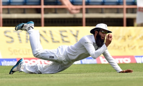 Moeen Ali catches a ball in an unsuccessful attempt to dismiss West Indies batsman Jason Holder.