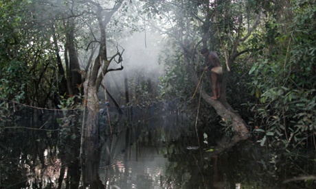 A Yawalapiti mans tries to spear fish to dry and save for a quarup, a ritual held to honor in death a person of great importance to them, in the Xingu National Park, Mato Grosso State