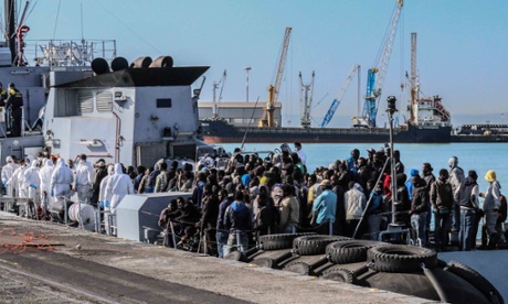 Rescued migrants wait to disembark off the Italian Guardia di Finanza vessel Denaro at the Sicilian harbour of Catania.