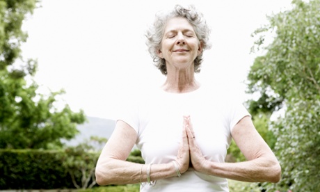 A woman meditating in the garden (posed by model)