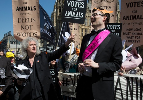 Campaigners speak as the Queen musician and activist Brian May looks on at an animal welfare rally.
