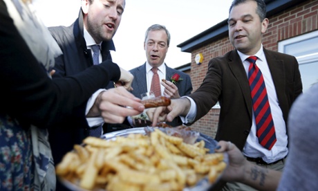 Nigel Farage and reporters eat sausages during a visit to mark St George's Day in Ramsgate.