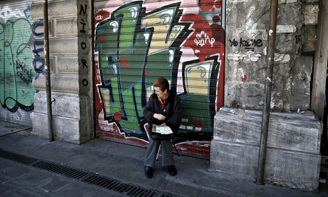 A woman selling lottery tickets outside a closed shop in central Athens.