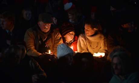 People hold candles in remembrance at the dawn service in Canberra.