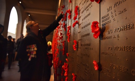 A woman places a poppy on the wall of remembrance after the dawn service at the Australian War Memorial in Canberra.