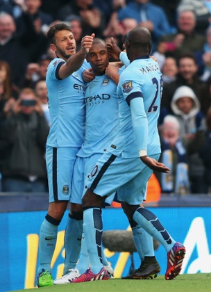 Fernandinho celebrates his winning goal with Martin Demichelis, left, and Eliaquim Mangala