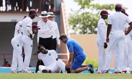 Jason Holder looks to be in pain as he receives treatment.