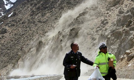 People run away from a landslide triggered by a tremor, after a 7.9-magnitude earthquake hit Nepal on Saturday, in Nyalam county, Tibet.