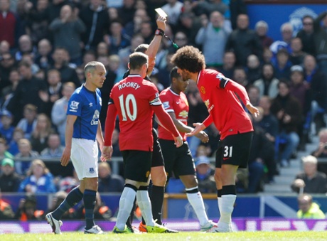 Marouane Fellaini is shown a yellow card by referee Andre Marriner.