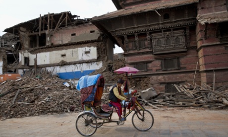 A Nepalese cycle rickshaw puller pedals past buildings at the Basantapur Durbar Square that were damaged in Saturday s earthquake in Kathmandu, Nepal.