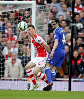 Laurent Koscielny under pressure from Cesc Fabregas.