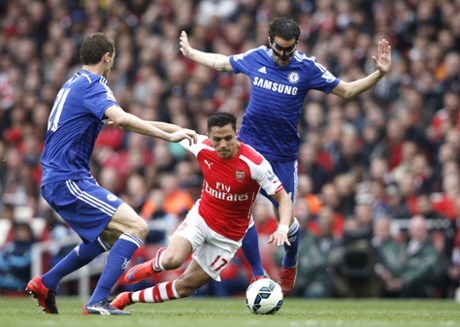 Alexis Sanchez tackled by Cesc Fabregas.