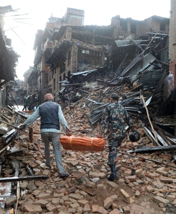 A Nepalese volunteer and member of the security forces carry tents to be distributed in Bhaktapur on Sunday.