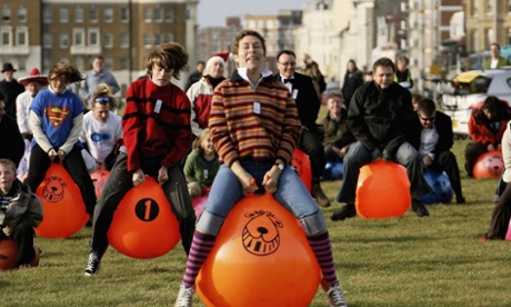 people bounce on orange Spacehoppers 