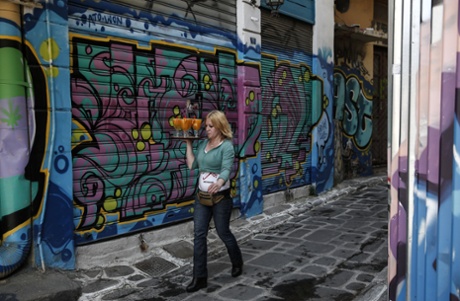 A waitress carries drinks at a pedestrian street of Athens, on Monday, April 27, 2015.  An opinion poll shows a majority of Greeks are dissatisfied with the new government's performance, and half want it to compromise with its European creditors if current tortuous bailout negotiations reach an impasse.  (AP Photo/Yorgos Karahalis)