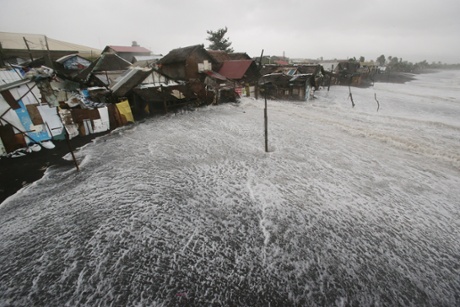 Waves crash into coastal houses as typhoon Hagupit pounds Legazpi, Albay province, eastern Philippines in December 2014.
