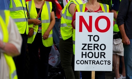 Striking workers hold a placard reading 