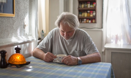 Portrait of senior man sitting at breakfast table looking down at teacup