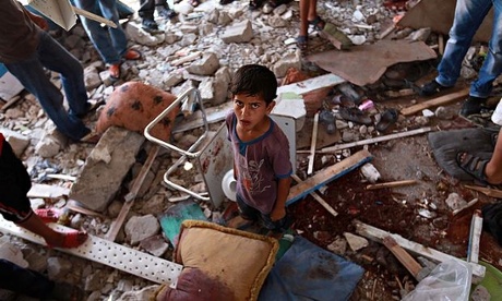 Palestinians inspect a damaged classroom of the UN school in Jabalia, northern Gaza, 30 July 2014.