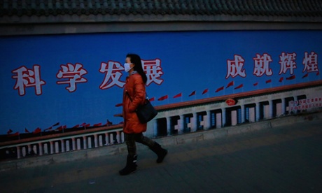 A woman wearing a face mask to protect her from poor air quality. The wall behind her reads “scientific development and amazing achievement”.