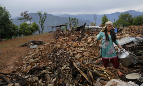 A woman recovers cooking pots from her collapsed home in Paslang near the epicentre of Saturday’s massive earthquake in the Gorkha district of Nepal.