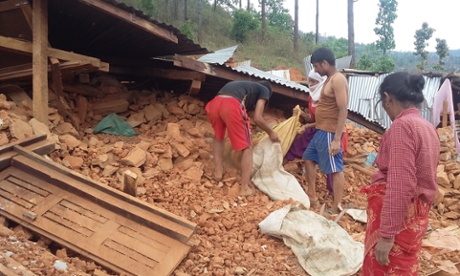 A family tries to recover some belongings from their collapsed home, in Sindhupalchowk district, Nepal.