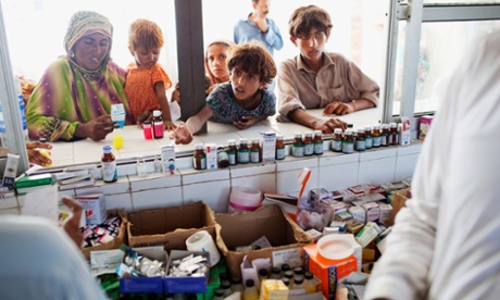 Flood affected villagers wait to receive medicine at a makeshift medical centre