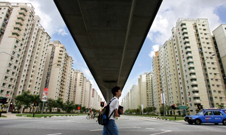 A student walks across public housing states after attending school in Singapore August 5, 2004
